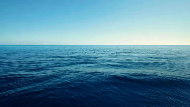 A video featuring a vast body of water with a clear blue sky stretching across the horizon, An endless blue ocean under a clear day sky