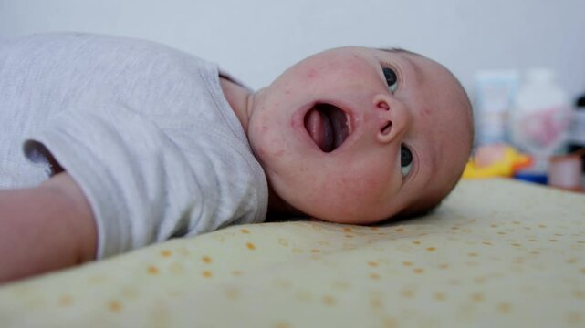 Beautiful newborn caucasian boy aged 3 months lies on the table, close-up