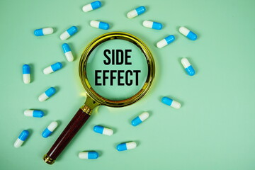 Medicine Capsule and Magnifying glass with SIDE EFFECT text on green background