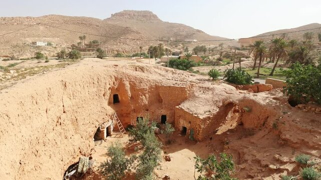 Traditional ancient Berber troglodyte underground dwellings in Tunisian town of Matmata with arched doorways carved into earth and communal well in courtyard. High quality 4k footage