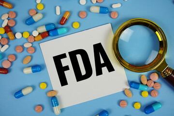 FDA - Food and Drug Administration text on sticky note paper with Medicine and Maginfying glass on...