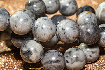 Beautiful round beads of gray jasper in macro photography, perfect for crafting and jewelry design. Decorative round stone beads of gray color  for boho jewelry design.