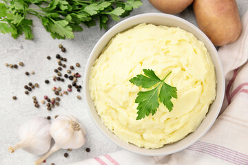 Mashed potatoes in white bowl on grey concrete background. Healthy food