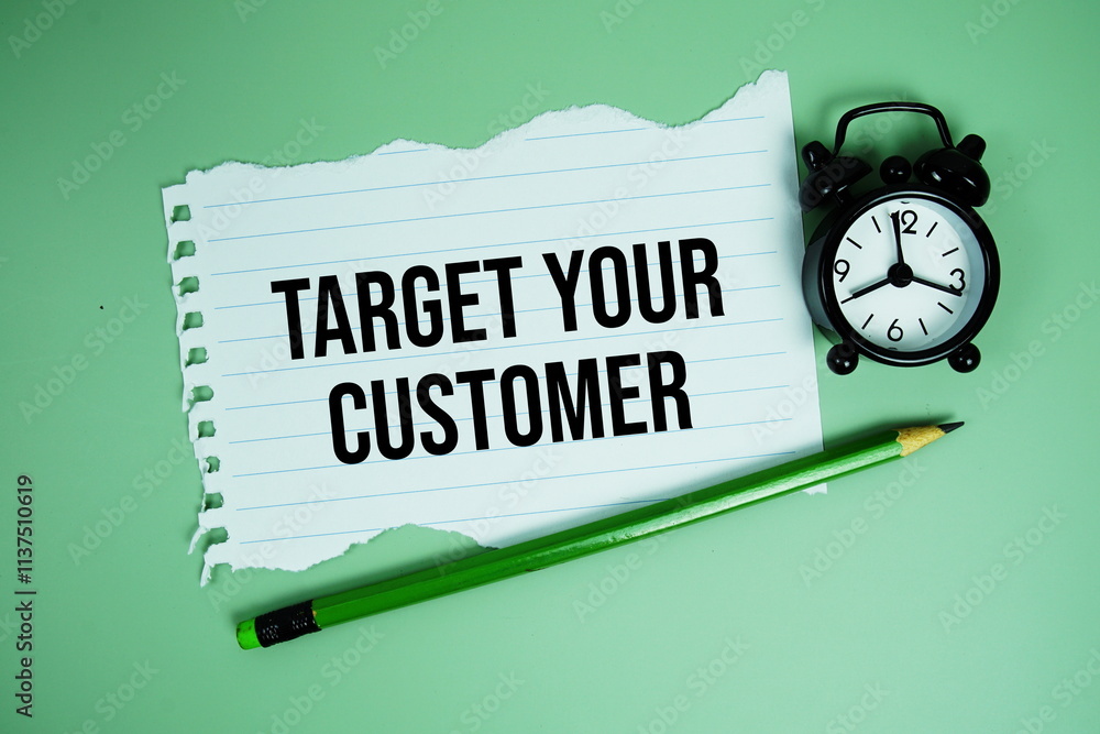 Poster target your customers text written on paper card with alarm clcok on green background