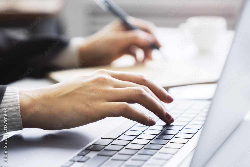 Aufkleber female hands in sharp focus typing on a modern laptop keyboard, office environment in soft blur behi
