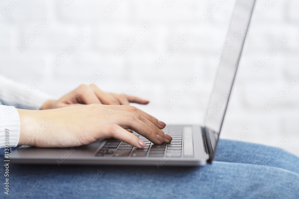 Aufkleber Close-up image of female hands typing on a cutting-edge laptop keyboard, with a soft blur of an office setting in the backdrop