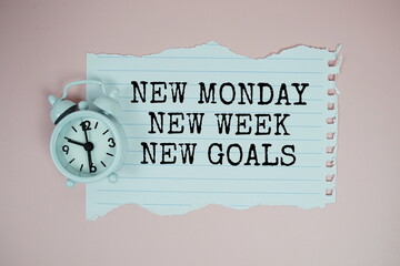 New Monday New Week New Goals text motivational and inspiration quote with alarm clock on pink...