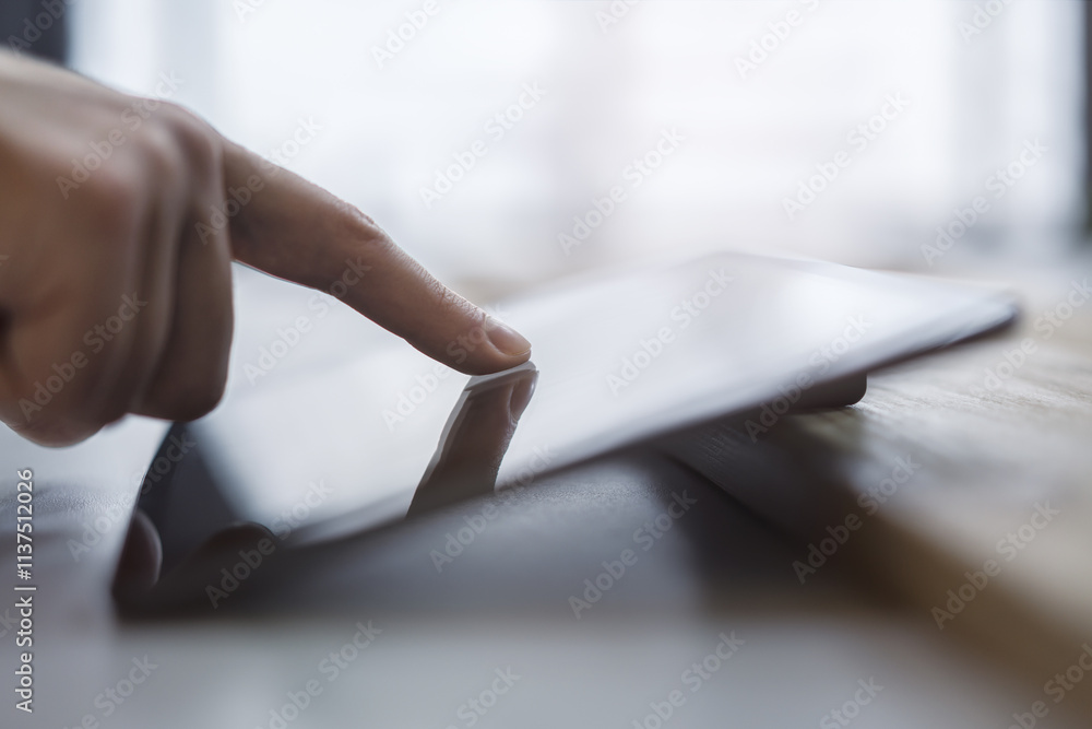 Poster detailed observation of a man's finger navigating the screen of an advanced tablet, device placed on