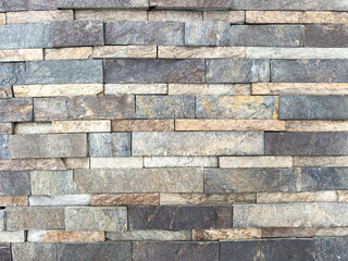 A wall made of stone bricks with a gray and brown color