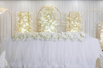 A table with white flowers and a gold frame. The flowers are arranged in a way that creates a sense of elegance and sophistication. The gold frame adds a touch of luxury to the scene
