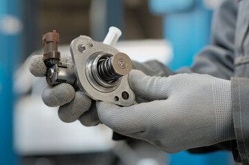 Spare parts.The new high-pressure fuel pump is in the hands of an auto mechanic.A specialist checks...