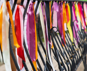 A fence is covered in colorful ribbons