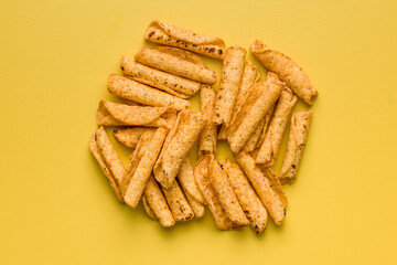 Rolled nachos tortilla chips on yellow background. Top view.