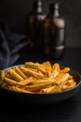 Rolled nachos tortilla chips on plate on black table.