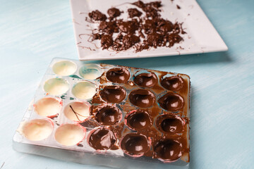 Confectioner's hands fill with chocolate, molds for making homemade chocolates using a cooking bag