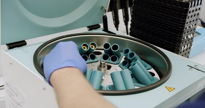 Centrifuge machine with vials in laboratory. From above centrifuge machine with test tubes spinning then stopping during workday in modern lab.
