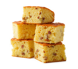 Delicious squares of cornbread with pieces of corn and a golden, fluffy texture stacked on a white surface