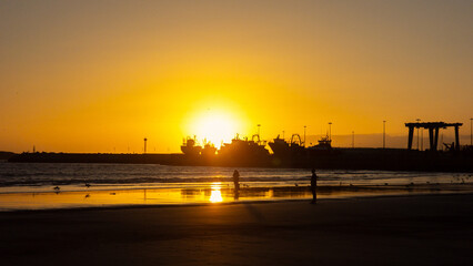 sunset on Essaouira beach, in front of the port, in Morocco