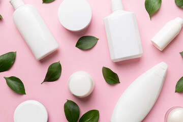 Organic cosmetic products with green leaves on color background. Flat lay