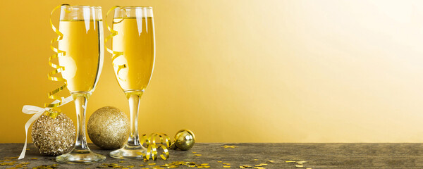 Champagne glasses and christmas decor on colored holiday background. Flat lay New Year decorations