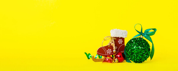 Christmas ball with skates on colored background. decoration bauble with ribbon bow with copy space
