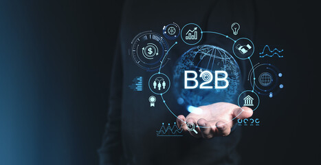 B2B business technology concept with hand holding network icons on dark background.