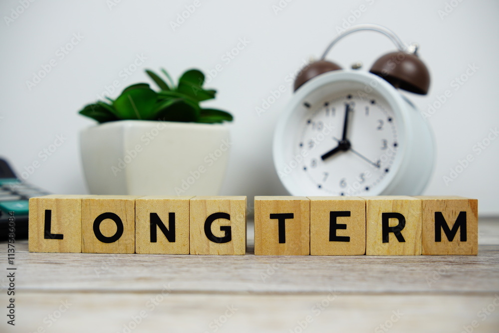 Poster alarm clock with wooden blocks alphabet letters long term text message on wooden background