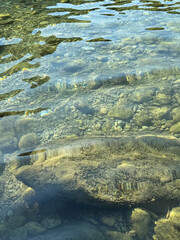 Clear transparent water with stones pebbles sand at the bottom