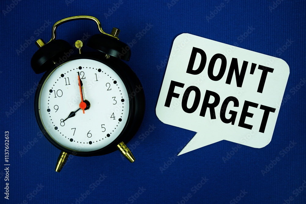 Aufkleber don't forget text on speech bubble with alarm clock top view on blue background