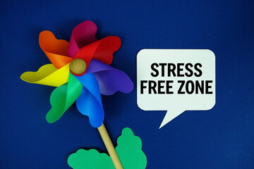 Stress Free Zone text  motivational and inspiration quote with colorful pinwheel top view on blue background
