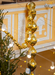 A gold colored string of balloons hangs from the ceiling