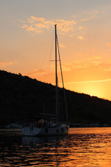 Sunset in Gümüslük Bodrum Silhouette of sailing boat in middle of lagoon under 	