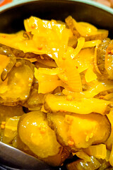 Pieces of pickled cucumbers and onions with spices. Close-up, vertical photo.