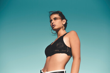 Portrait of teenage girl wearing black top against sky