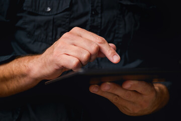 Man using digital tablet computer, low key