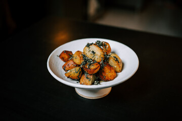 Fried Potatoes With Herbs Served on a White Plate in a Cozy Dining Setting During a Casual Meal