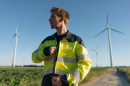 Engineer on field path at a wind farm looking around