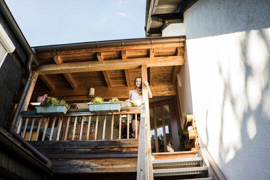 Smiling woman standing on balcony