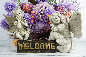 Welcome sign with flowers bouquet and angel statues home decorations