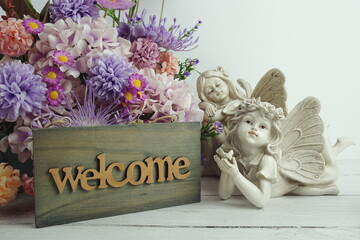 Welcome sign with flowers bouquet and angel statues home decorations