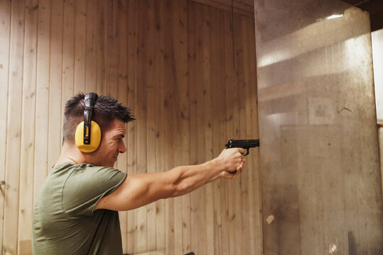 Man aiming with a pistol in an indoor shooting range