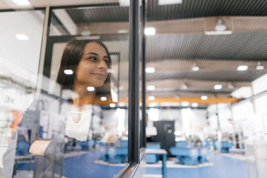 Confident woman working in high tech enterprise, looking out of control room