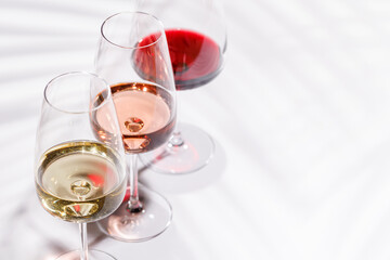 Three wine glasses filled with red, white, and rose wine