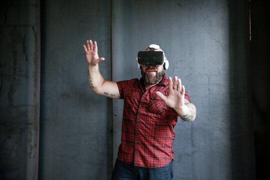 Excited bearded man wearing VR glasses