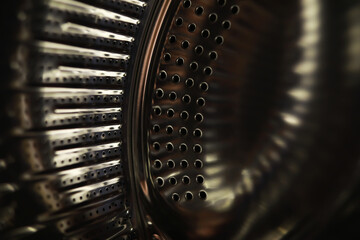 Close-Up of Metallic Washing Machine Drum with Stainless Steel Texture and Circular Holes