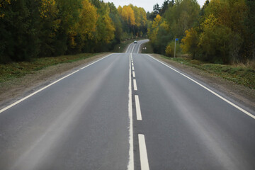 Scenic Autumn Road Through Forest with Vibrant Foliage and Clear Sky