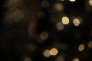 Obraz premium Defocused Warm Golden Bokeh Lights in a Soft Dark Background