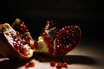 Fresh Pomegranate with Juicy Seeds in Dramatic Lighting on Dark Background