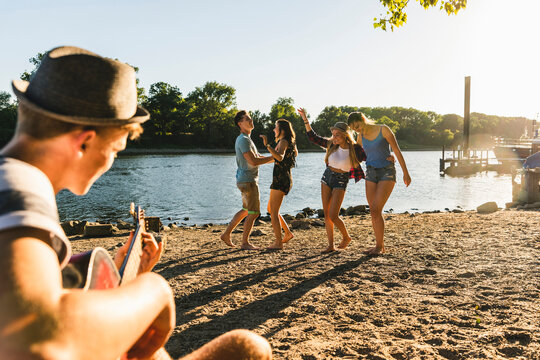 Group of friends having a party at the riverside