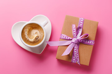 A romantic Valentines Day setup featuring a gift box and a steaming cup of coffee